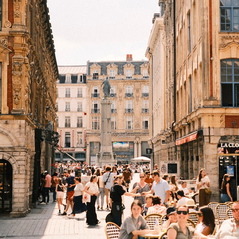 People enjoying apéritif on Lille's Grand Place, a lively cultural moment during a French homestay immersion