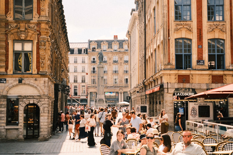 People enjoying apéritif on Lille's Grand Place, a lively cultural moment during a French homestay immersion