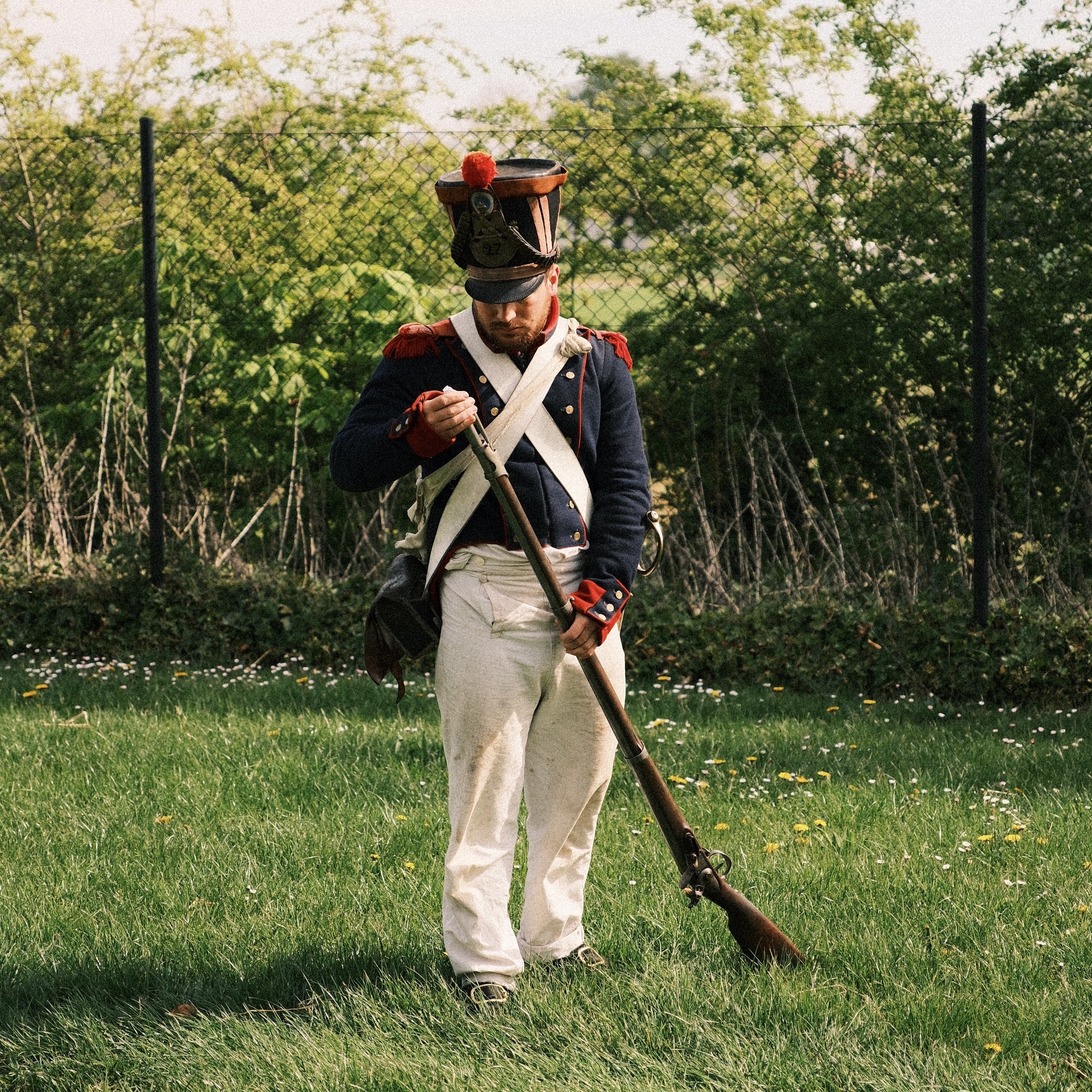Napoleonic soldier performing a musket firing demonstration during a historical reenactment in France