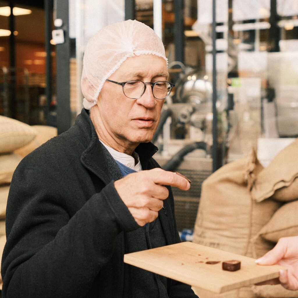 Student tasting handmade chocolate in a traditional French chocolate factory near Lille